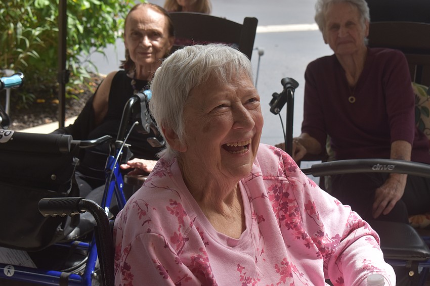 Carol Wilson, a resident at The Windsor of Lakewood Ranch, enjoys the entertainment of Jesse Daniels Band and fellow residents dancing at the 20th anniversary celebration.