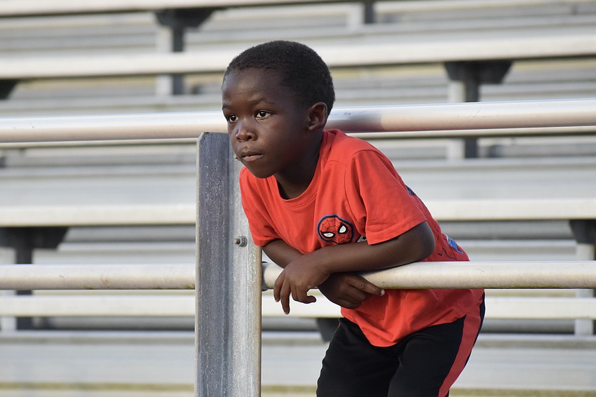 Knowledge Lazier, 4, watches as the athletes warm up.