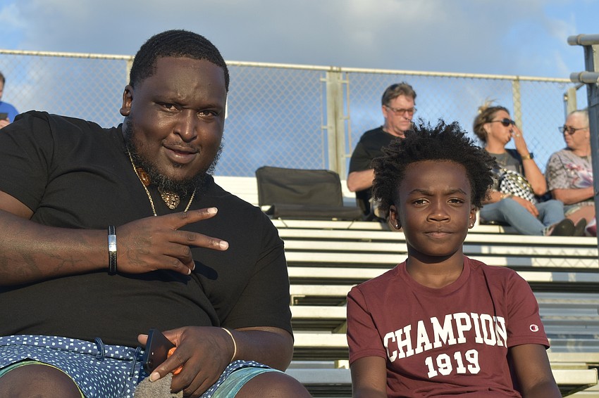 Darion Lazier and his son Derick White, 9, enjoy the game.