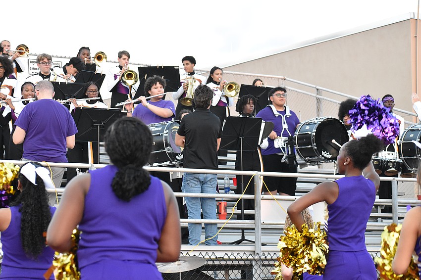 Booker High School's cheerleaders perform in front of its marching band.