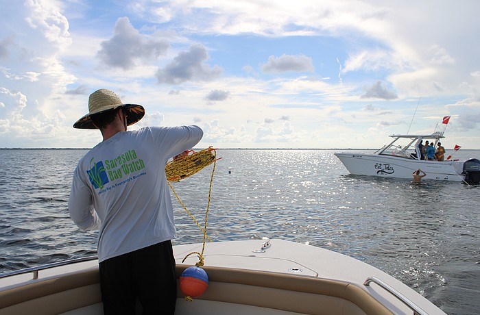 Volunteer Peter Bonk spools out line for the grid-based search for scallops in Sarasota Bay during the Great Scallop Search of 2025.