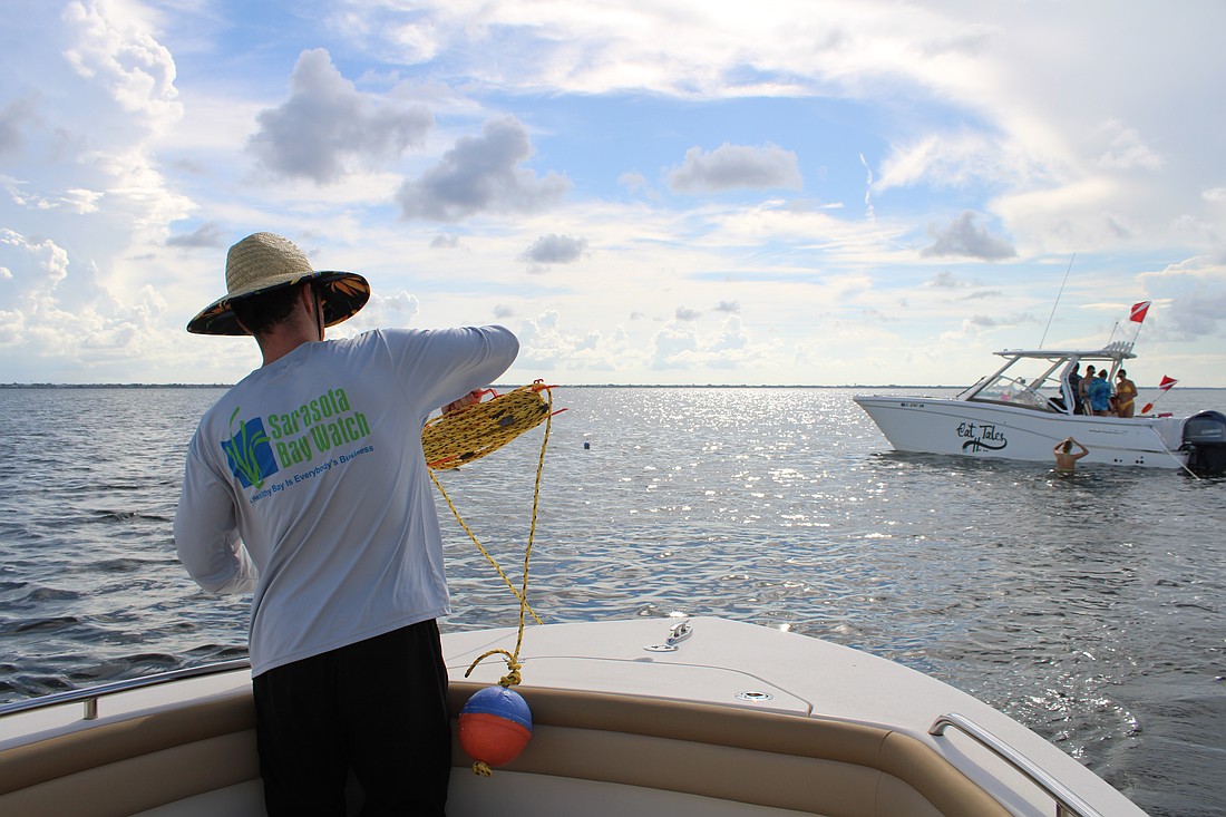 Volunteer Peter Bonk spools out line for the grid-based search for scallops in Sarasota Bay during the Great Scallop Search of 2025.