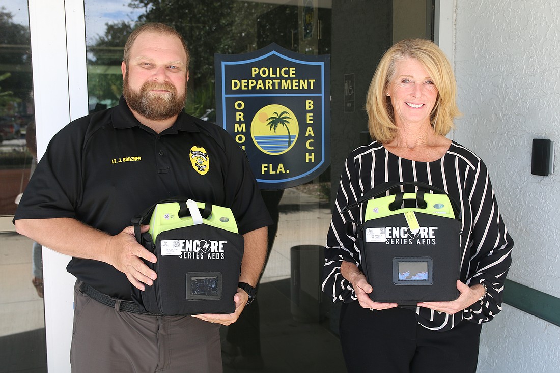 Ormond Beach Police Lt. John Borzner and City Commissioner Lori Tolland hold the new AEDs. Photo by Jarleene Almenas