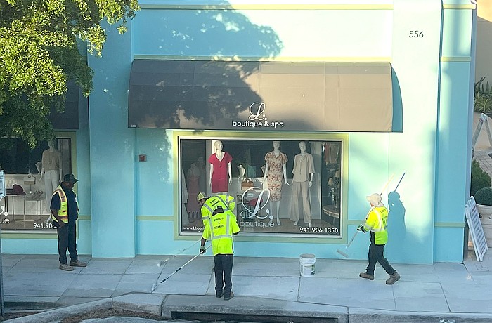 City of Sarasota Public Works personnel work on removing sidewalk murals in Burns Court.