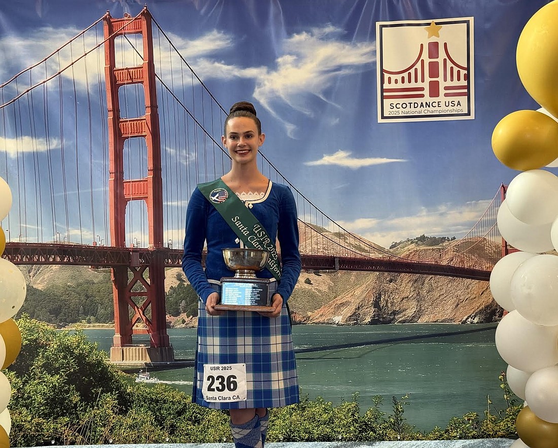 Allison Williams smiling with her trophy from the championship.