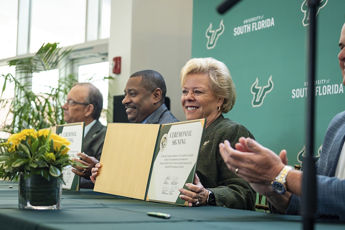University of South Florida President Rhea Law holds the university's $85 million contract with the US Army at a signing ceremony on Sept. 4.