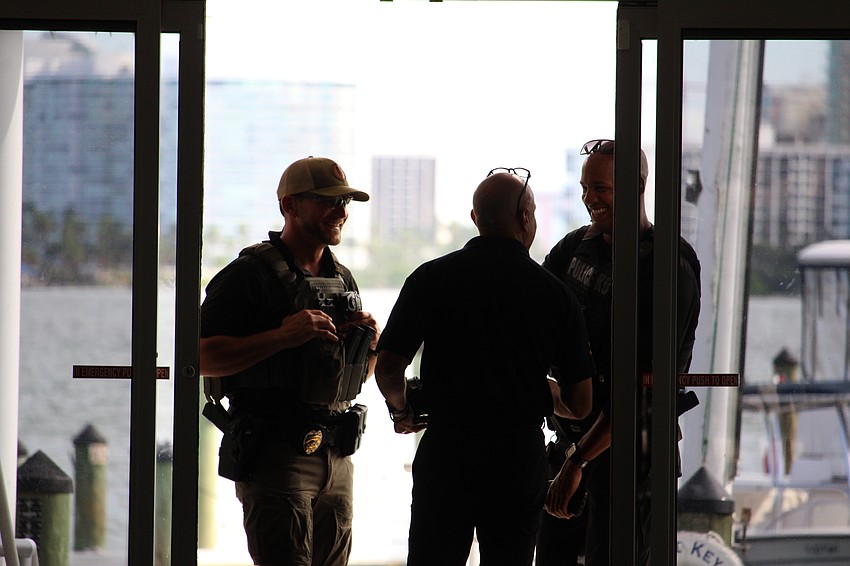 Sarasota Police Department Sgt. Dustin Luciano, left, and officer Adam Bearden, K-9 specialist, greet Capt. Demetri Konstantopoulos at an explosive entry training on Sept. 5 at Bird Key Yacht Club.