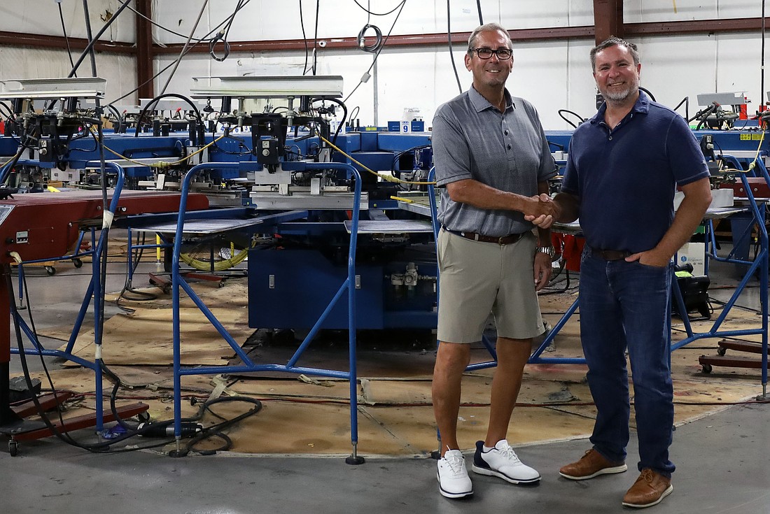 Bill Cournan, who founded contract apparel decorator BC Sales in 1991, shakes hands with Public Products founder Chris Abbott.