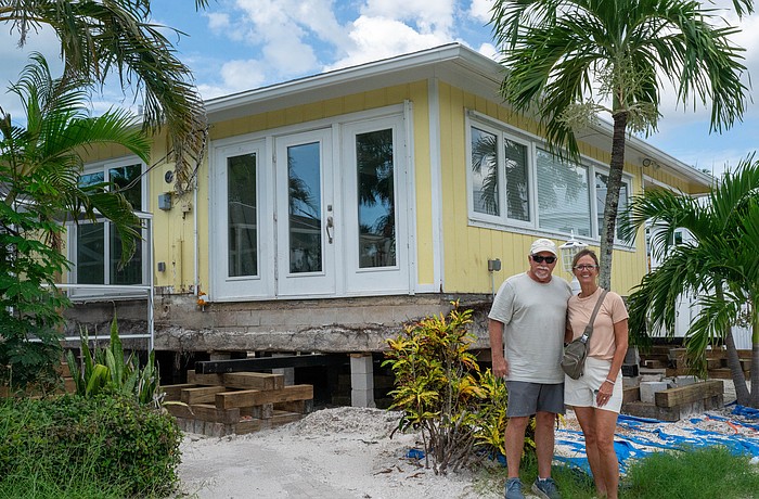 Chris and Sue Udermann stand outside their partially-raised house in The Village in Longboat Key, nearly a year after Hurricane Helene dumped feet of floodwater into their retirement home.