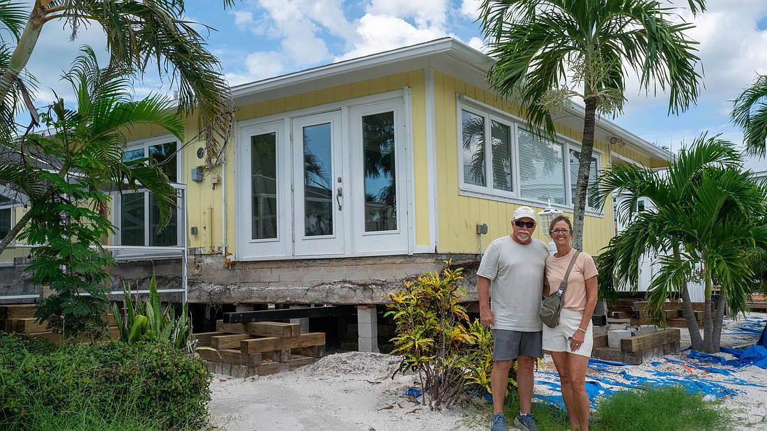 Chris and Sue Udermann stand outside their partially-raised house in The Village in Longboat Key, nearly a year after Hurricane Helene dumped feet of floodwater into their retirement home.