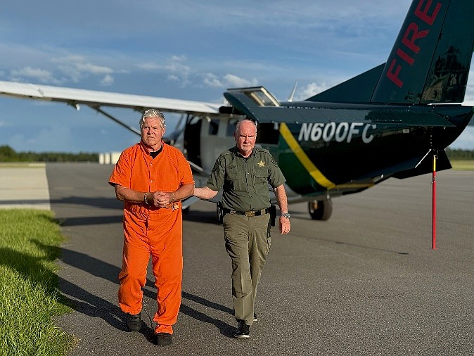 Kermit Booth, left, is escorted by Flagler County Sheriff Rick Staly, right, after arriving in Palm Coast on Friday, Sept. 5, 2025. Courtesy photo