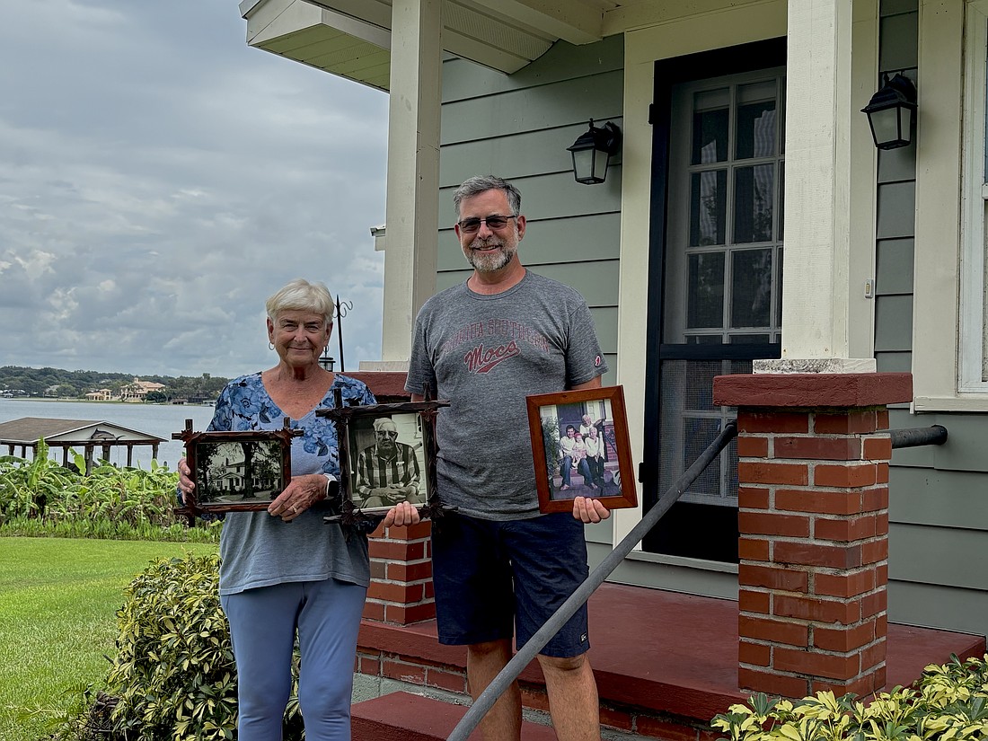 Andy Williams, a fifth-generation Windermere resident, and his mother, Lavina Williams, sit on the front porch of her home on Lake Down. All of the photos they are holding were taken on the same porch.