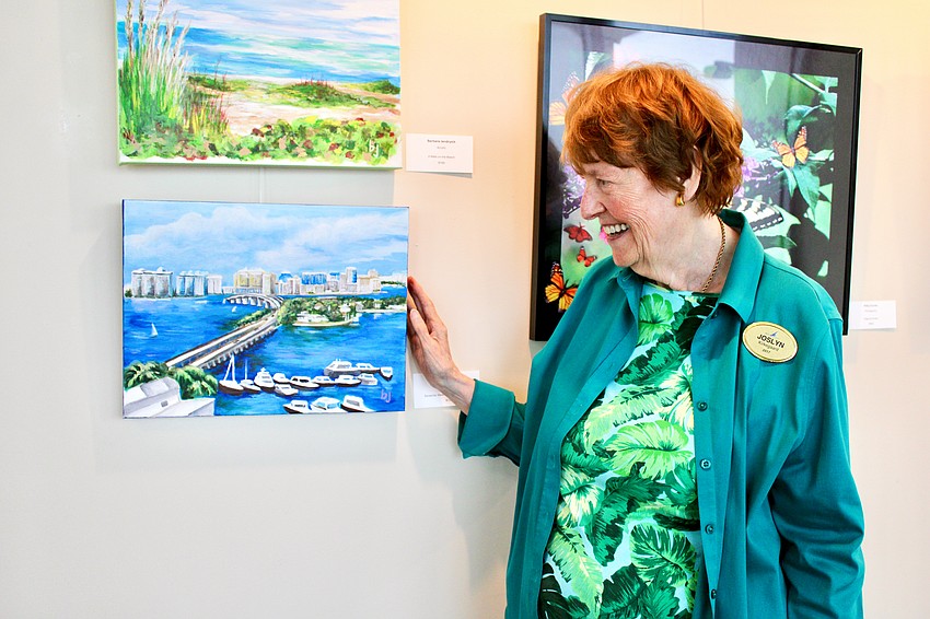 Plymouth Harbor resident Joslyn Kirkegaard purchases a painting by Barbara Jendrysik at the debut art exhibition evening organized by the local chapter of the National League of American Pen Women on Sept. 9 at Plymouth Harbour. The show will be open for the next few months.