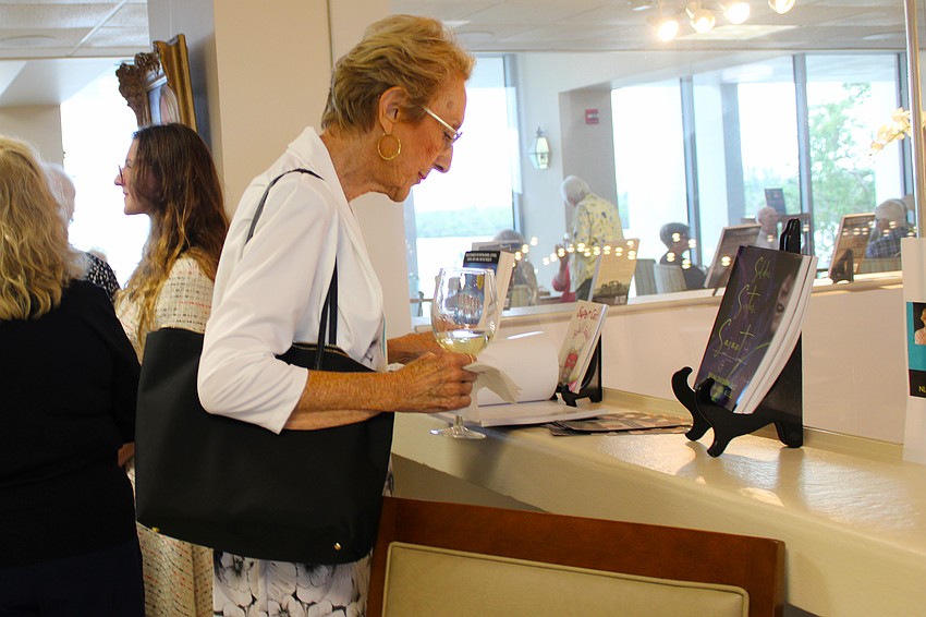 Art enthusiast Barbara Swan examines some of the featured authors at the Plymouth Harbor art exhibition on Sept. 9, held by the local chapter of the National League of American Pen Women, Inc.