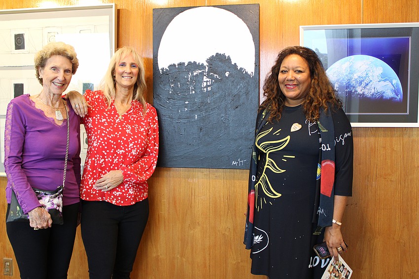 Artists Polly Curran, Jo Jo Fusco and Medge Jaspan brought their talent to a Sept. 9 exhibition opening at Plymouth Harbour. They pose for a snapshot by Jaspan's latest work, a texturized piece centered on a December full moon.