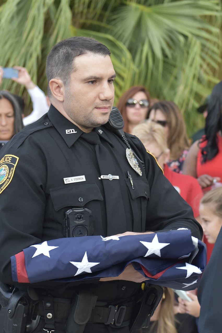 Officer Alex Stevenson of USF Sarasota-Manatee carries the flag.