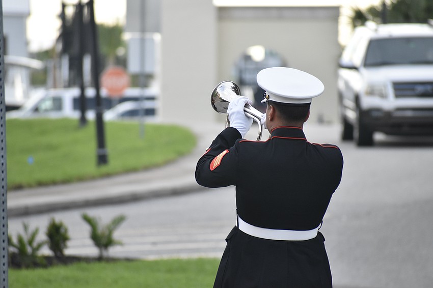 U.S. Marine Corps, 4th Amphibian Assault Battalion Sgt. Steven Adames plays taps during the flag raising ceremony.