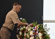 Staff Sergeant Matthew B. Miles of the United States Army, representing all military personnel, lays a wreath.