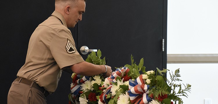 Staff Sergeant Matthew B. Miles of the United States Army, representing all military personnel, lays a wreath.