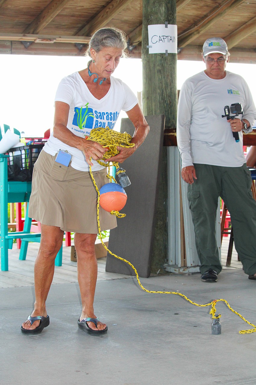 Rhonda Ryan, executive director of Sarasota Bay Watch, demonstrates how to lay out a transect line to guide volunteers' underwater search for scallops in Sarasota Bay.