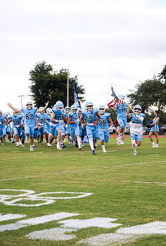 Foundation Academy's football team running out for a home game.