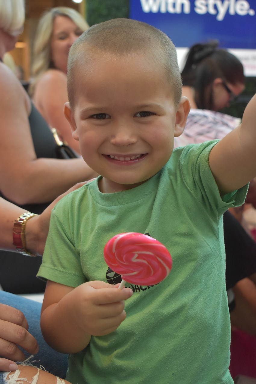 James Erickson, 3, enjoys the lollipop he received in his gift bag at the Men Wear Pink event at The Mall at University Town Center.