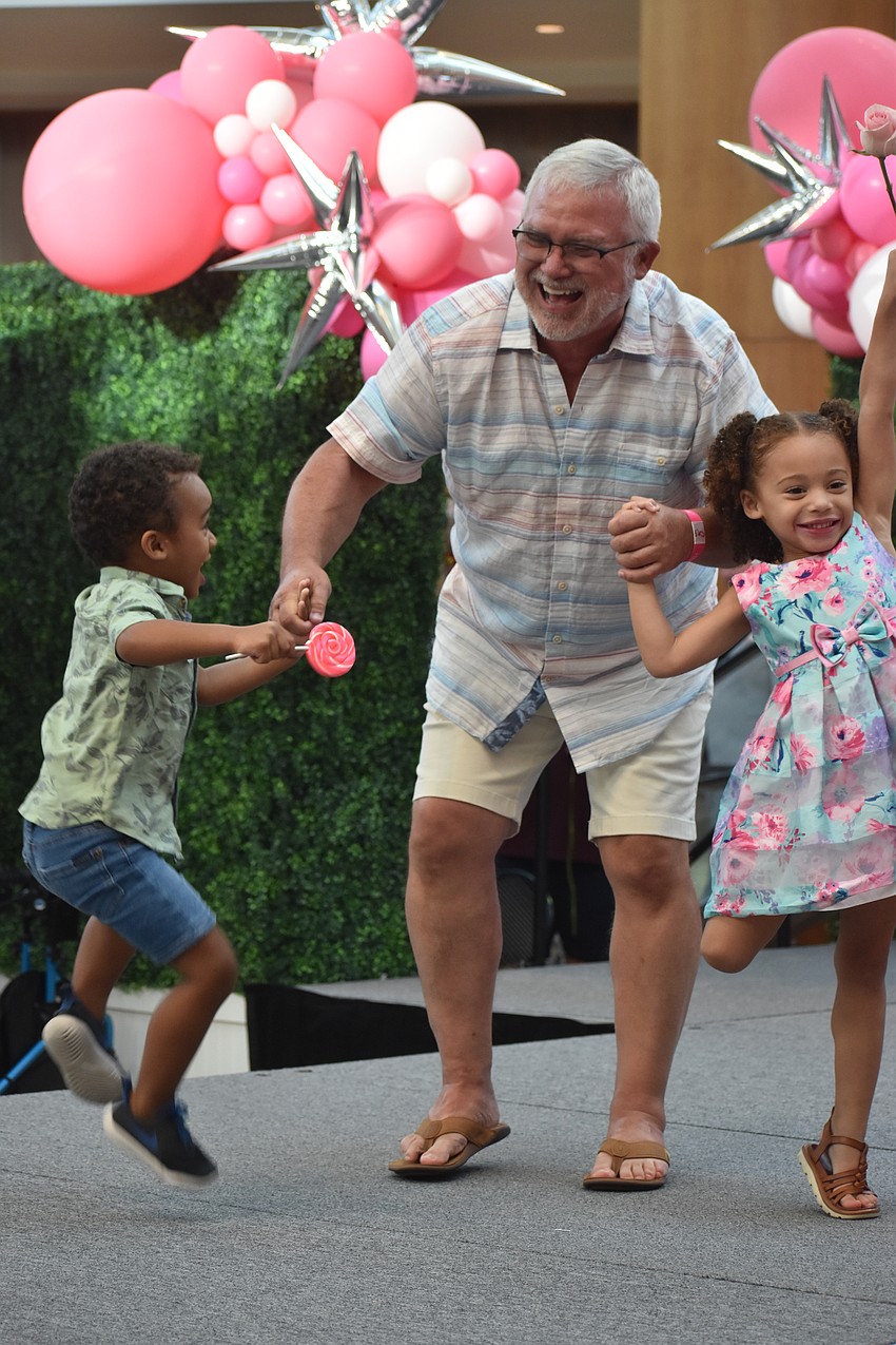 Rich Carroll of Home Team Inspection Services has been involved in Men Wear Pink for four years. He is joined on stage by 2-year-old Creed Carroll and 4-year-old Ruth Carroll.