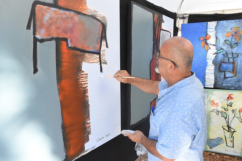 Orlando artist Kenan Sari whorls on a painting.