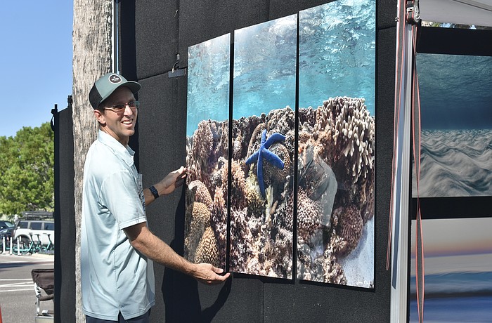 Bradenton photographer Jimmy Chadsey hangs a painting on the wall.