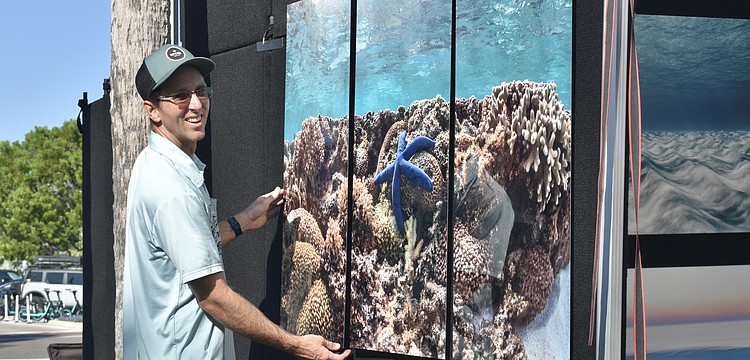 Bradenton photographer Jimmy Chadsey hangs a painting on the wall.