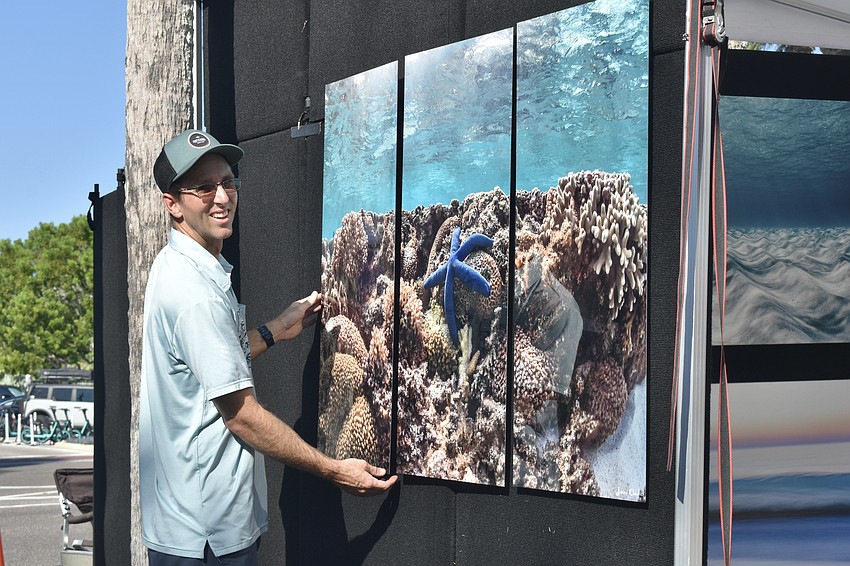 Bradenton photographer Jimmy Chadsey hangs a painting on the wall.