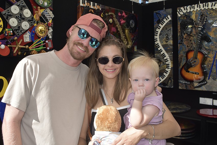 Chris Rolfes, Ashley Rolfes and their daughter Harper Rolfes, 1, enjoy the art.