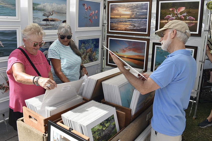 Linda Cahill and Danae Hoskins and Richard Jameson look at the art of Merritt Island artist LaDora Sims.