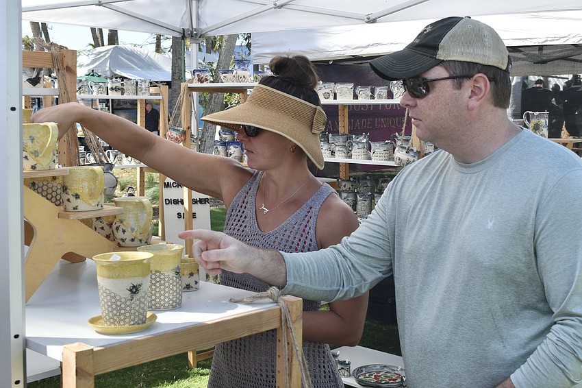 Liz Dollar and her friend Brad Pate look at ceramic cups.