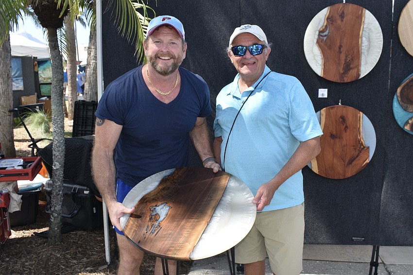At the American Woodworker tent, Robin Roberts sells a table to Bob McCafferty.