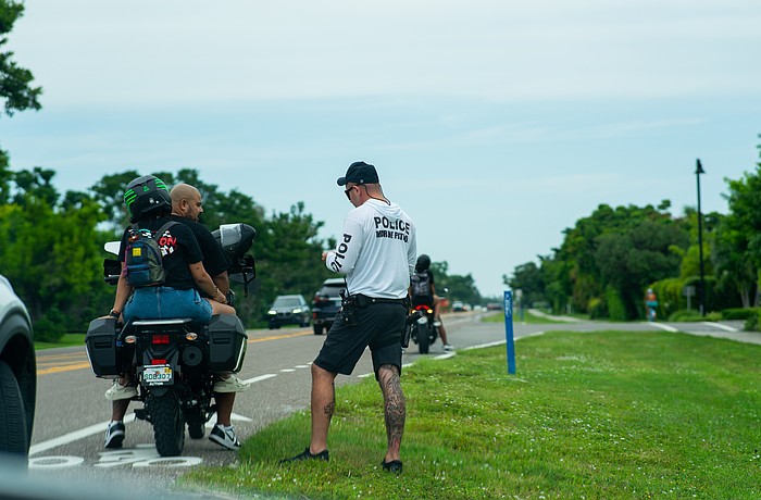 Longboat Key police Sgt. Adam Montfort speaks with bikers pulled over on Gulf of Mexico Drive Friday, Sept. 12 while the department was performing “high visibility enforcement.”