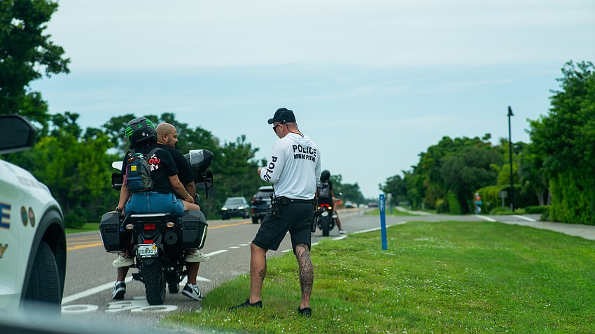 Longboat Key police Sgt. Adam Montfort speaks with bikers pulled over on Gulf of Mexico Drive Friday, Sept. 12 while the department was performing “high visibility enforcement.”