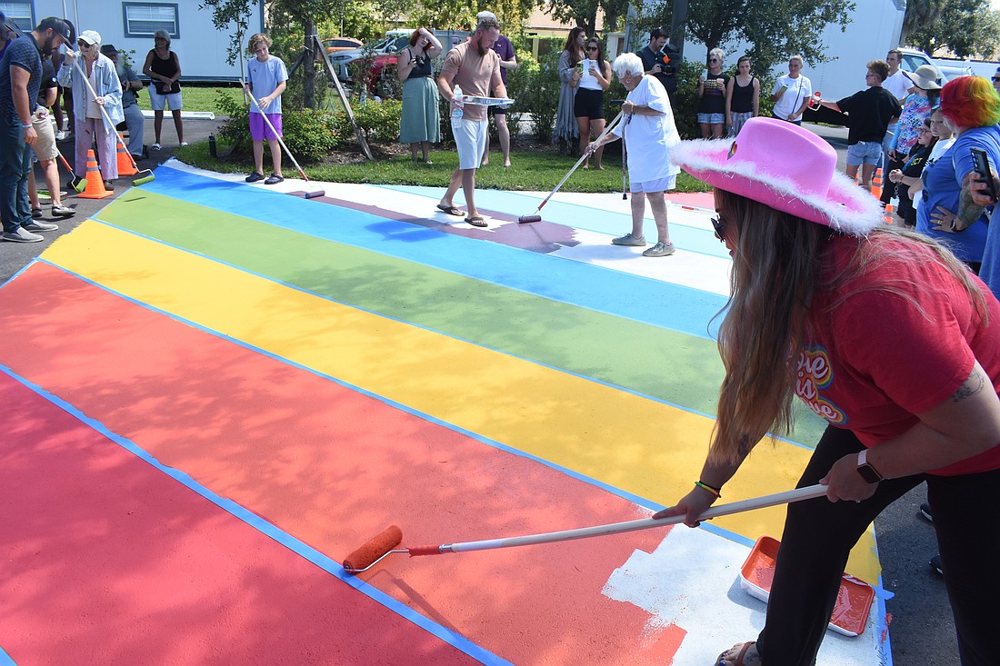 Attendees including Carissa Marsh (right) paint the walkway at The Harvest Sarasota on Sept. 14.