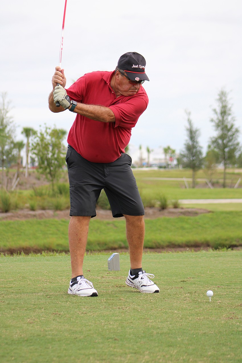 Peter Menard, who has been golfing for six months, swings his club during the Communi-tee Golf Classic at Calusa Country Club.
