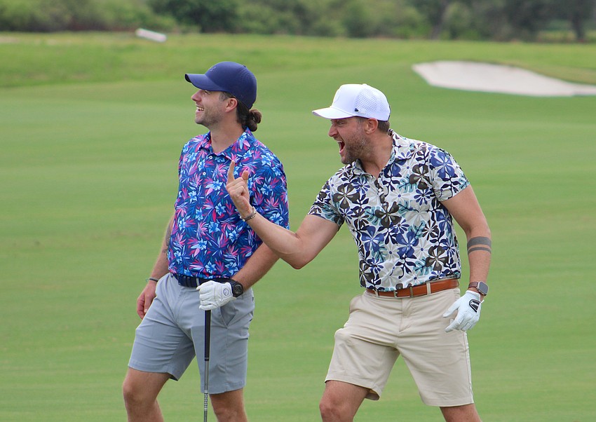 Ben Lacina and Alex Houston watch and celebrate as a friend participates in the Communi-tee Golf Classic by Lakewood Ranch Community Activities.