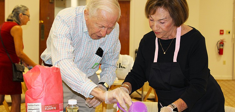 Jim Heskett and Marion Levine measure out flour for their challah at a free community baking workshop hosted Sept. 18 at Temple Beth Israel for Rosh Hashanah.