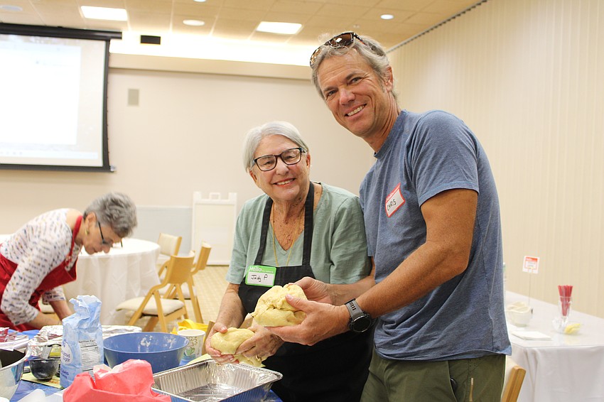 Chris Lesser and Judy Posner add the final touches to their challah loaves.