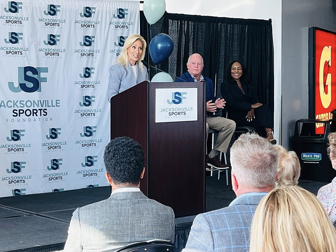 Jacksonville Mayor Donna Deegan announces the Florida High School Athletic Association basketball championships at the announcement Sept. 17 at VyStar Veterans Arena. Watching are  Michael Corrigan, board president of the Jacksonville Sports Foundation and president and CEO of Visit Jacksonville; and Samantha Vance, executive director of the Jacksonville Sports Foundation.
