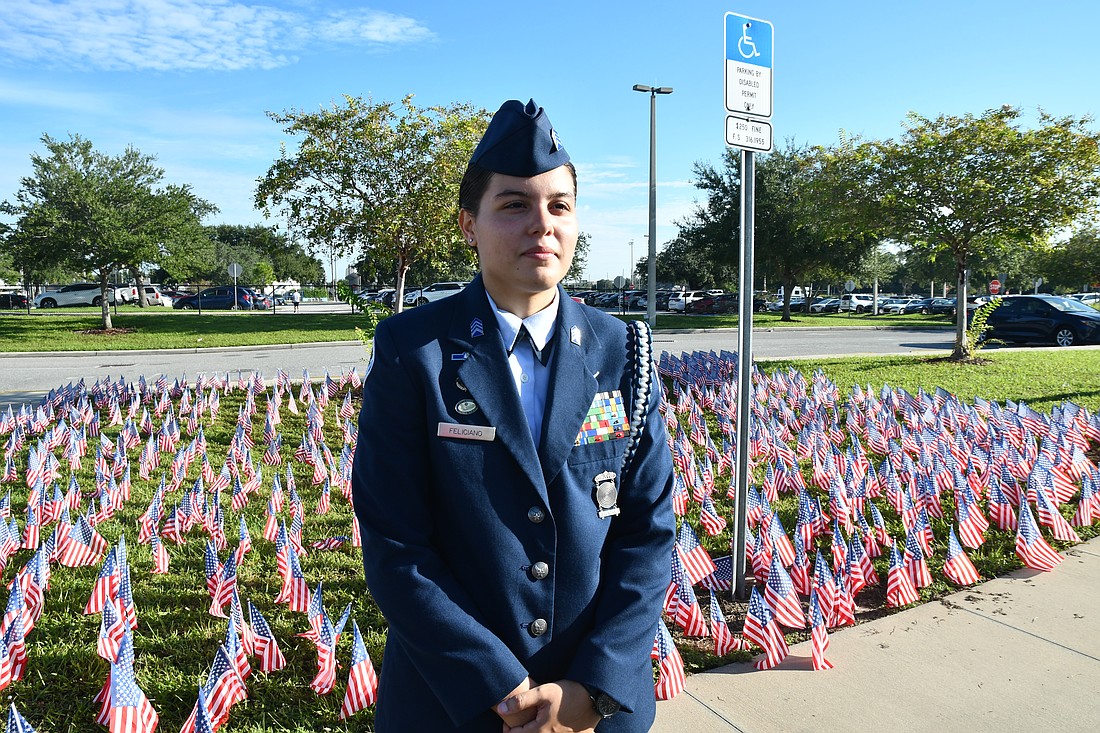 Mayra Feliciano stood in front of flags placed on the ground during Dr. Phillips High’s ceremony on Thursday, Sept. 11.