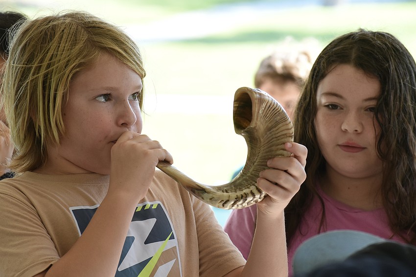 Daniel Polichuk, 10, blows the shofar as Sasha Leopold, 11, looks on.