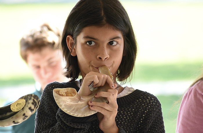 Vivian Masters, 10, blows the shofar.