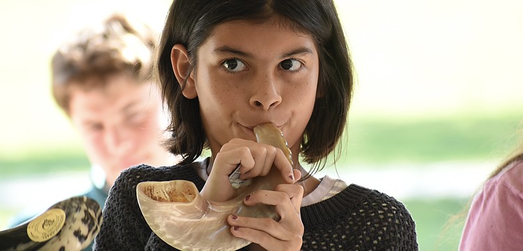 Vivian Masters, 10, blows the shofar.