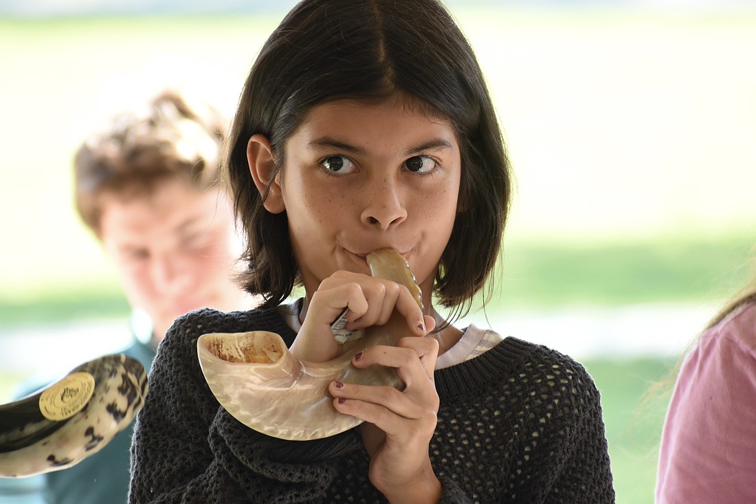 Vivian Masters, 10, blows the shofar.