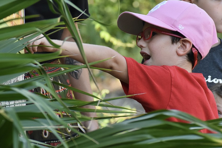Ben Bishop, 6, discovers a sign placed by the temple, as a group walks the trail in the park.
