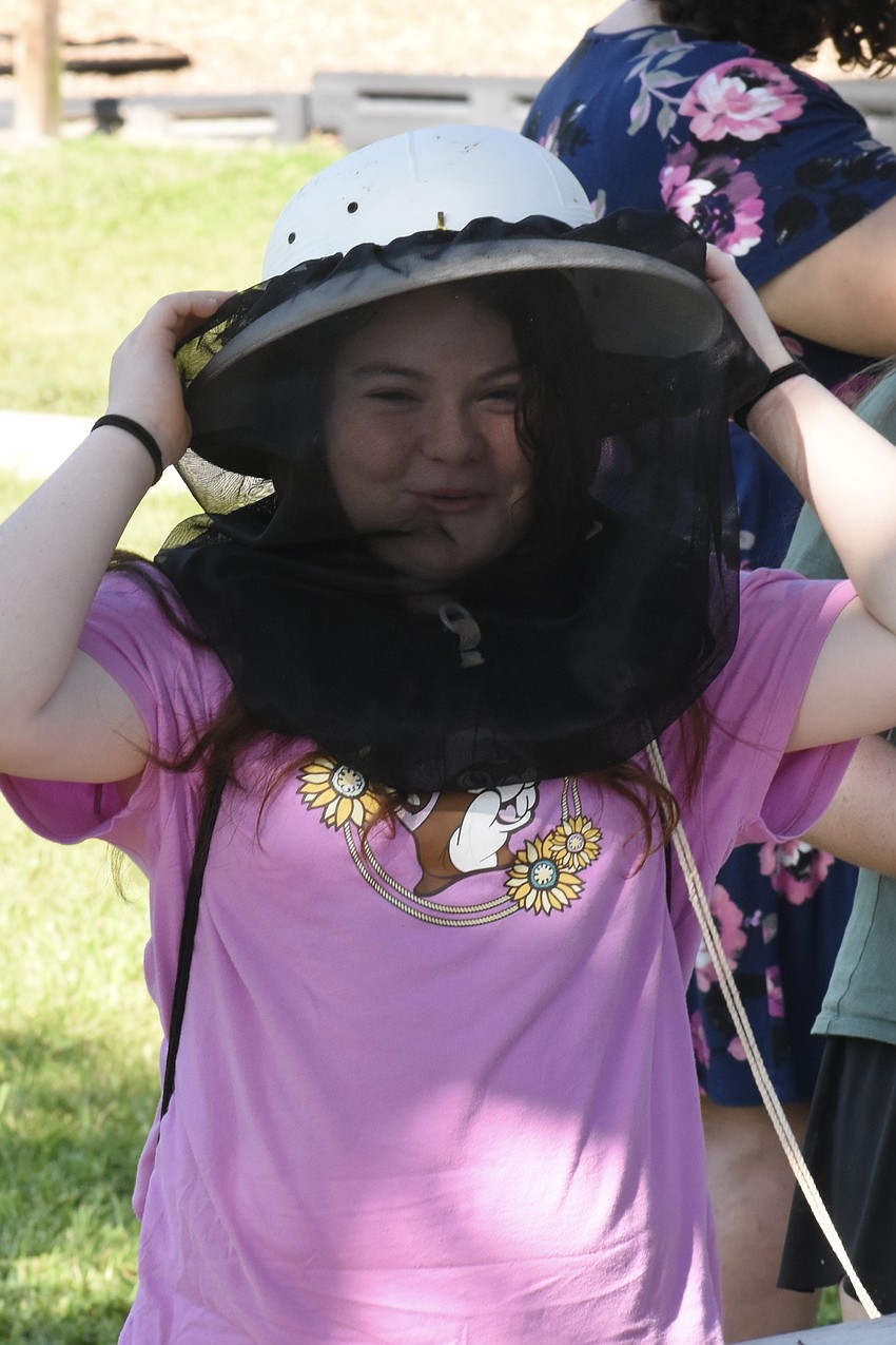 Sasha Leopold, 11, tries on beekeeping gear.